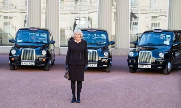 Patron Her Majesty Queen Camilla stands in front of three LTCFC Black cabs